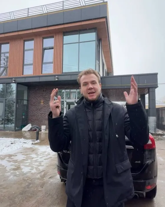 Прораб на площадке перед фасадом частного дома